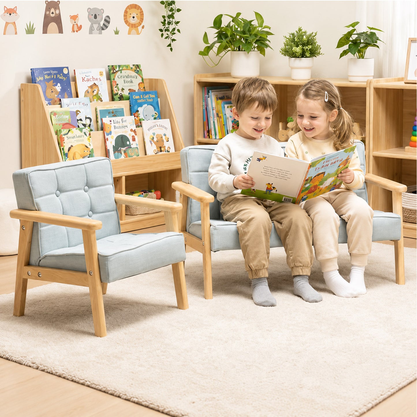 Zwei Kleinkinder lesen gemeinsam auf einem gepolsterten 2-Sitzer-Kindersofa