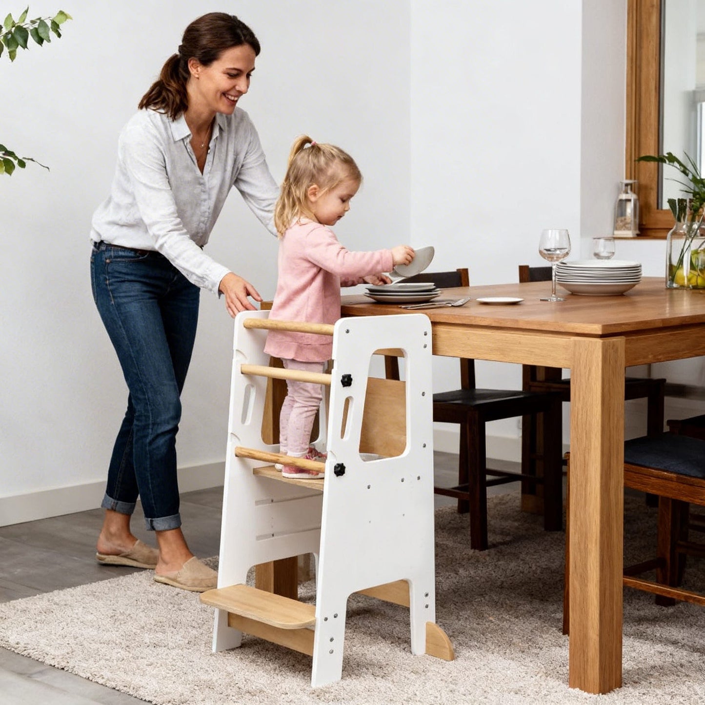 Kind und Mutter nutzen den Lernturm gemeinsam beim Kochen